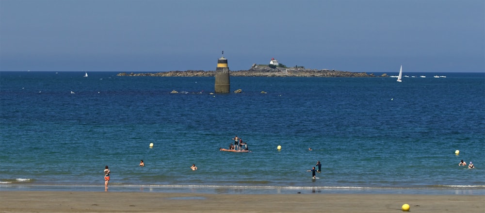 a group of people standing on top of a beach next to the ocean