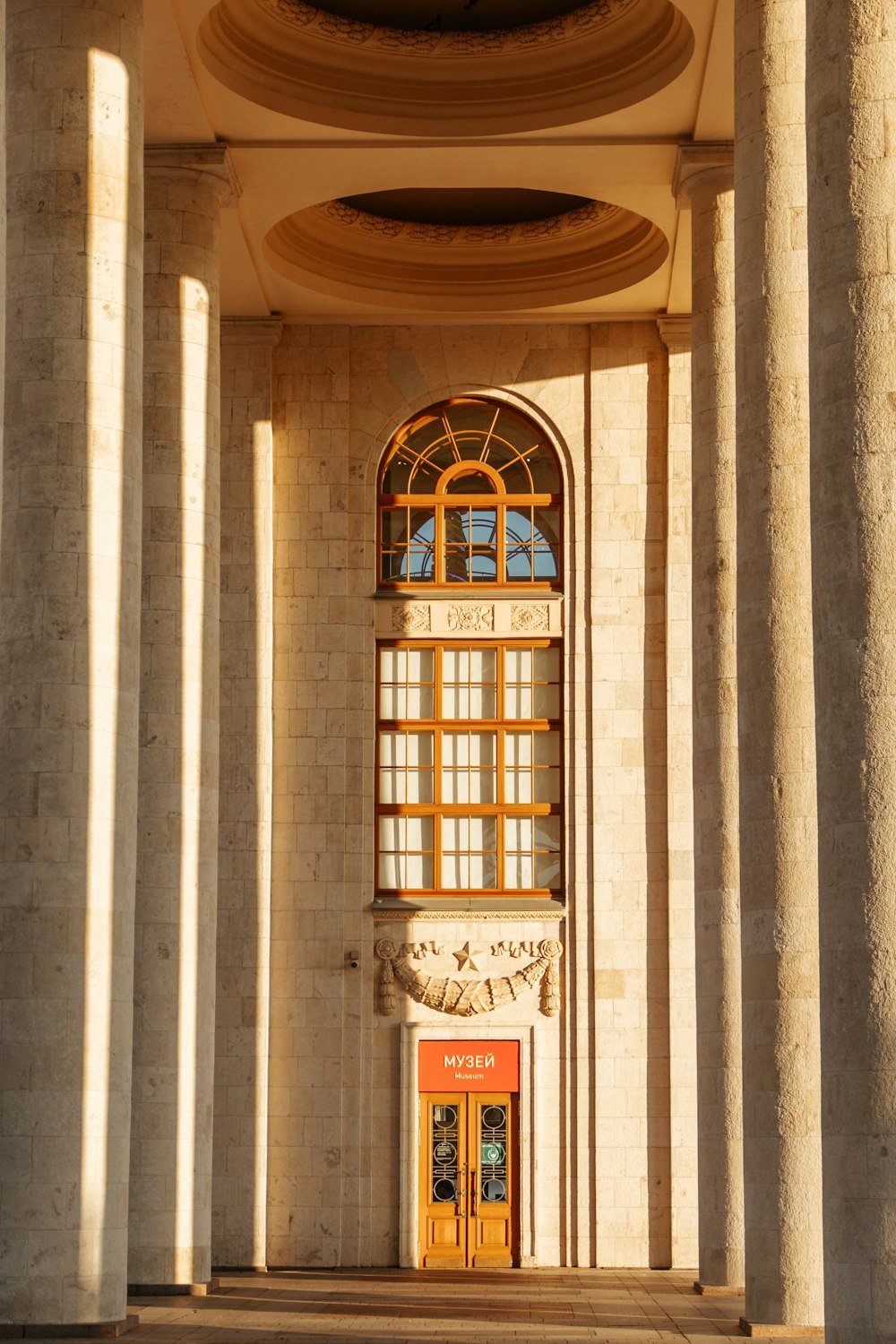 a building with columns and a clock on the front of it