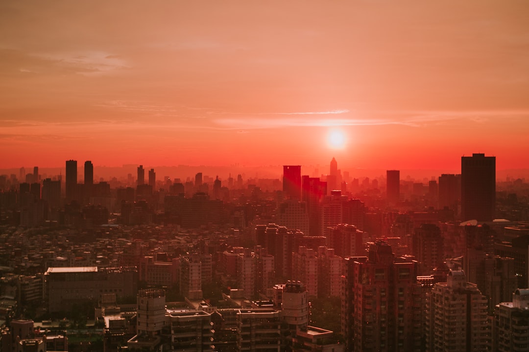 the sun is setting over a large city, A pink sunset over a city landscape.