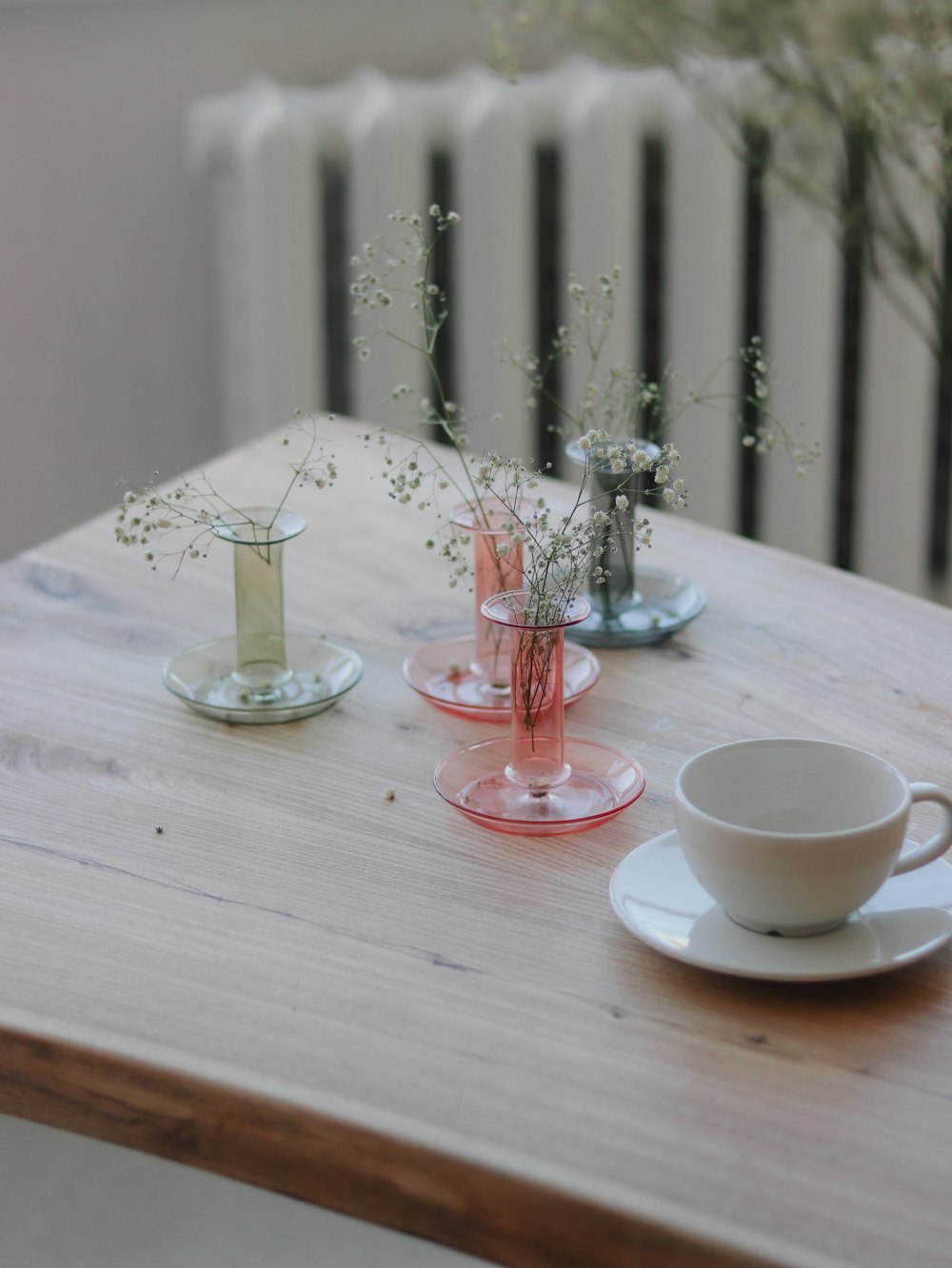 a wooden table topped with cups and saucers