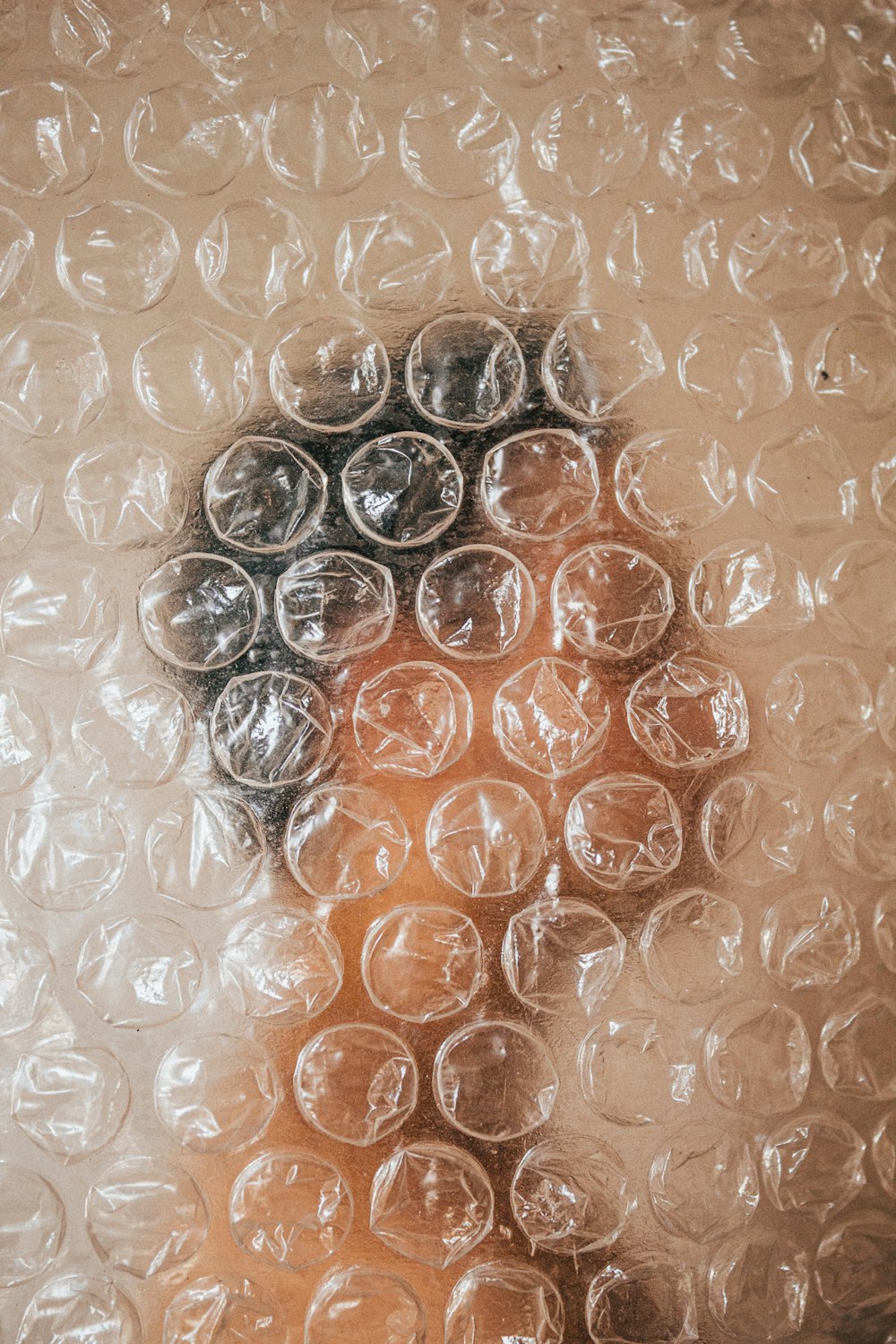 um close up do rosto de uma pessoa através de um plástico bolha