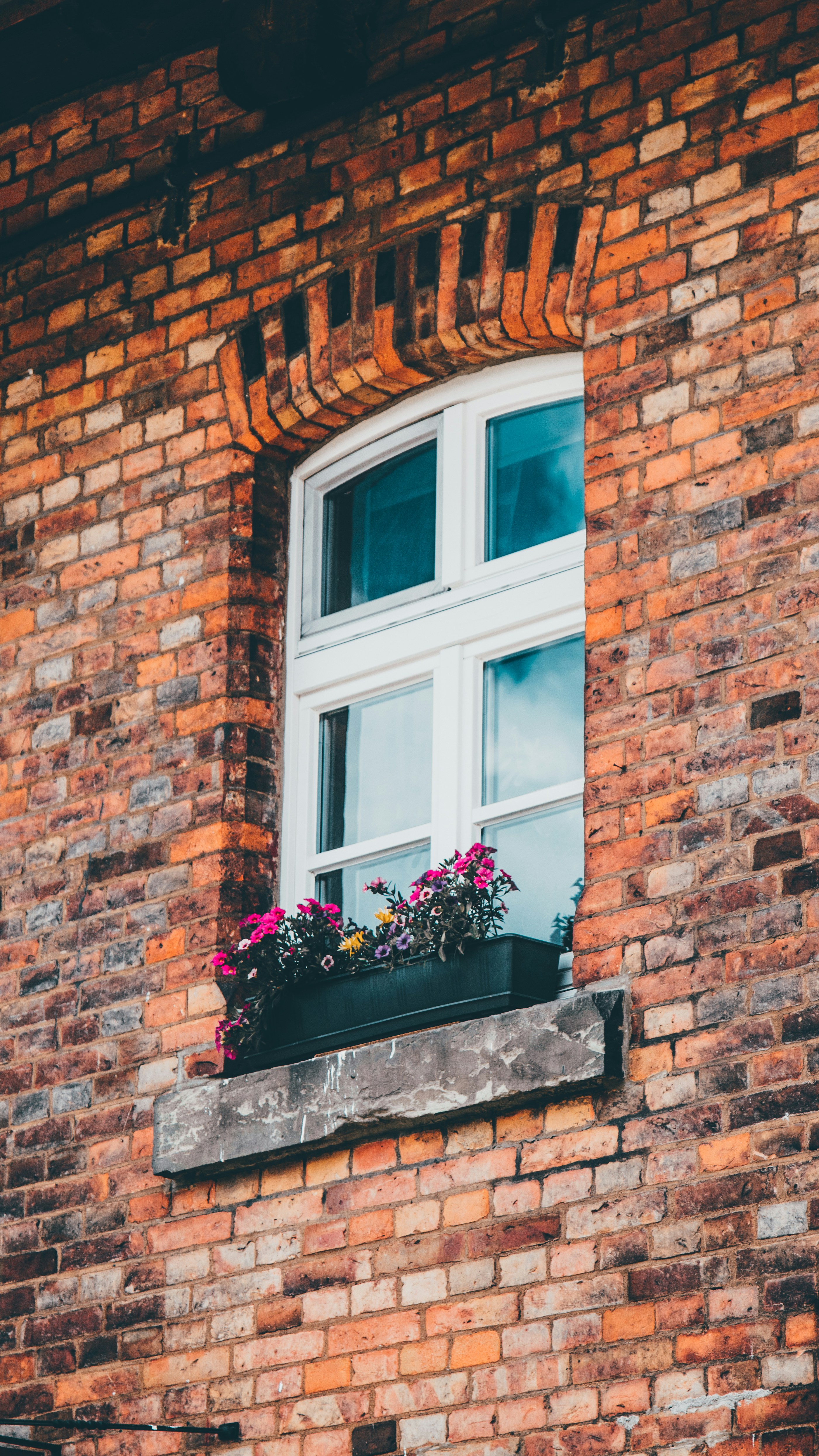 a brick building with a window and flower box