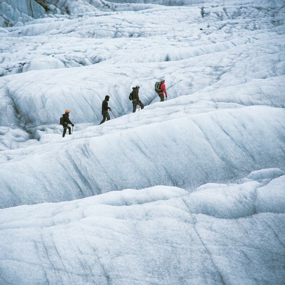 a group of people walking across a snow covered slope