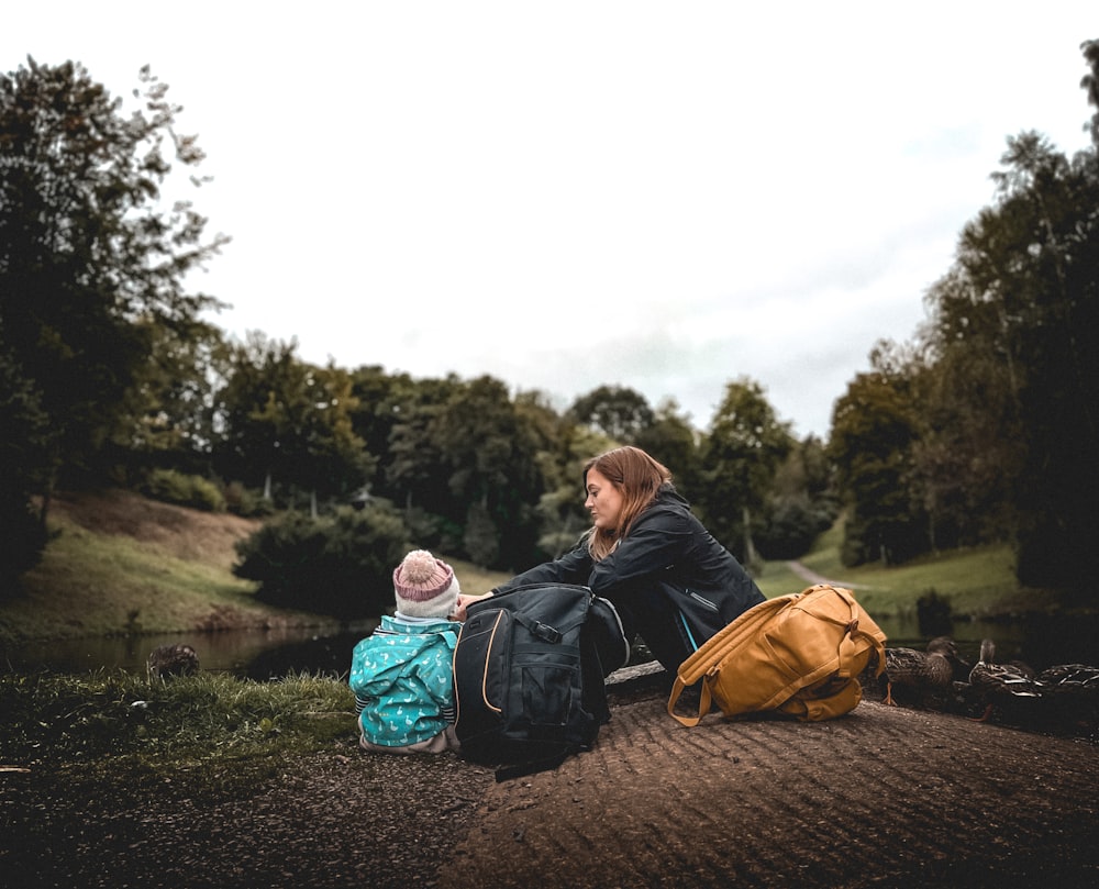 a woman and a child are sitting on the ground