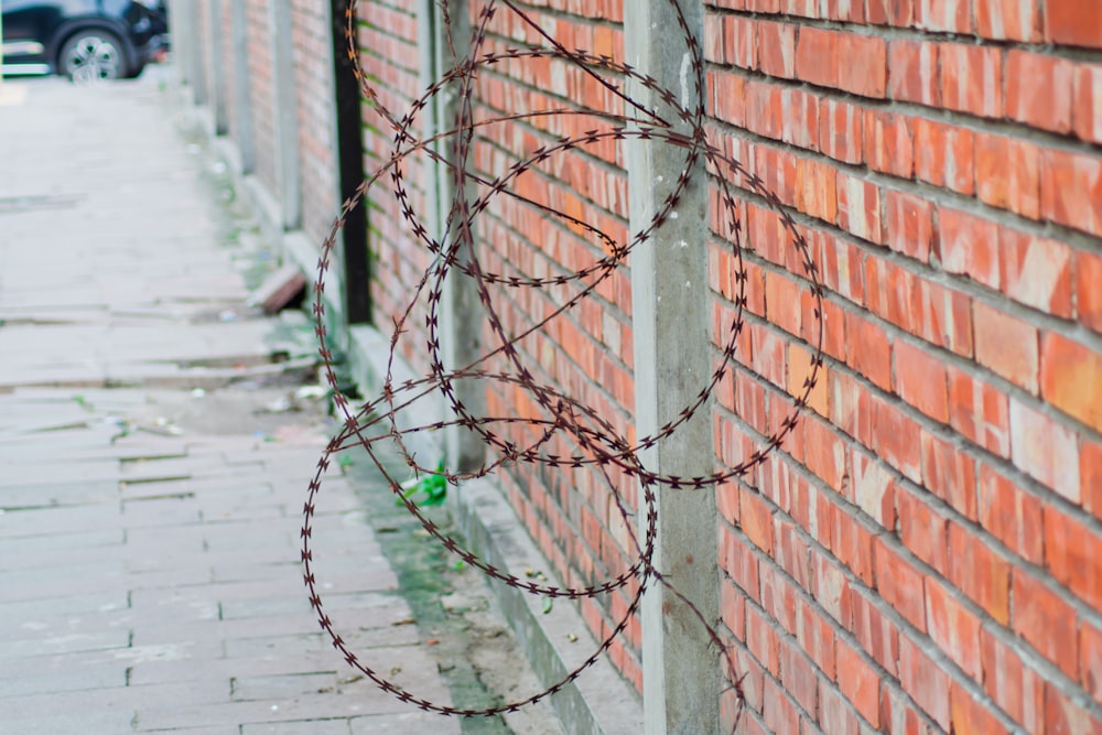 a red brick wall with barbed wire on it