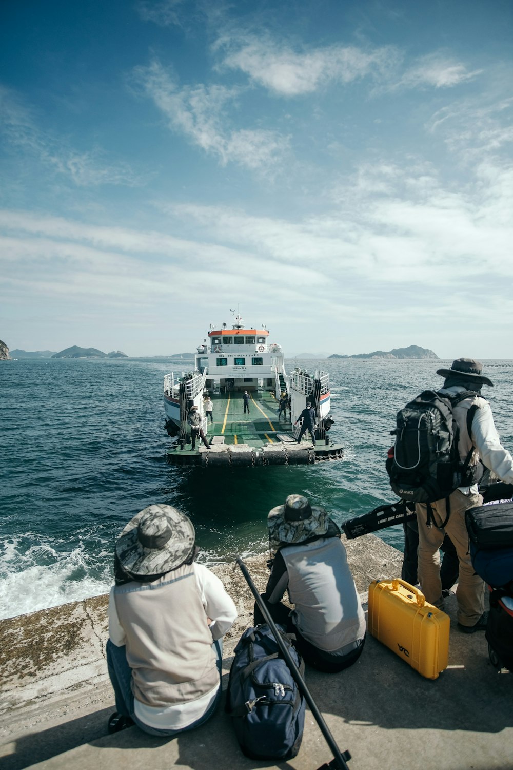 a couple of people sitting next to a boat on a body of water