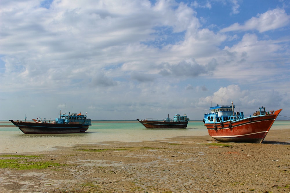 um grupo de barcos sentados no topo de uma praia de areia