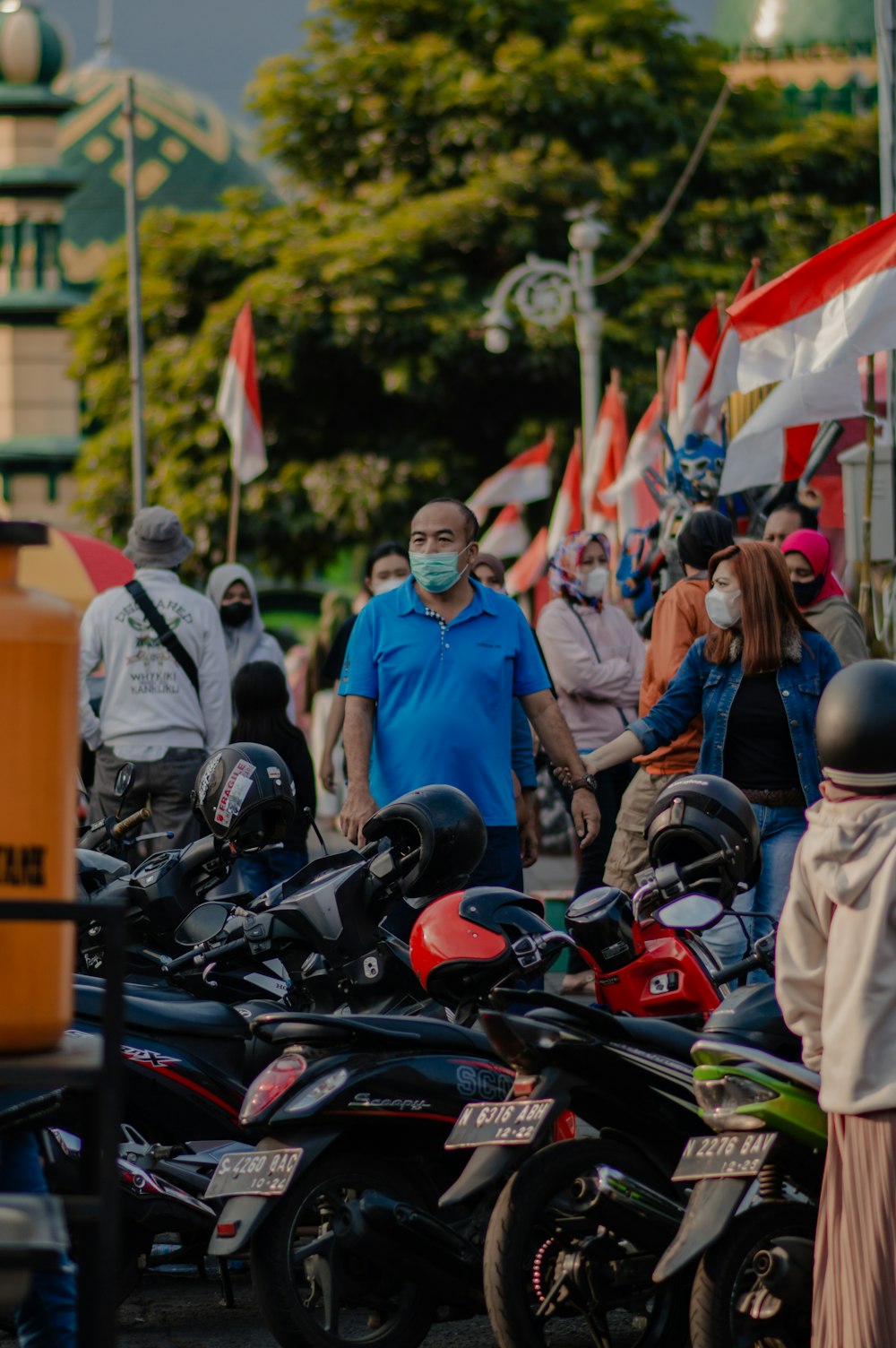 a group of people standing around a bunch of motorcycles