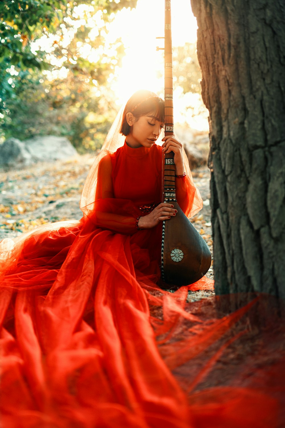 a woman in a red dress is holding a guitar