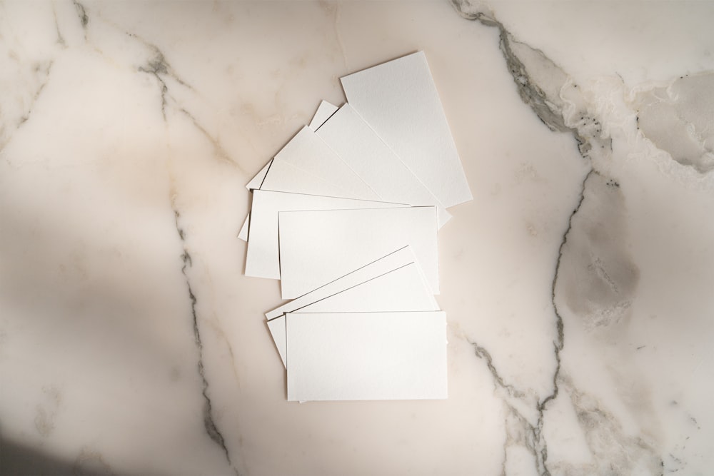 a pile of white paper sitting on top of a marble counter