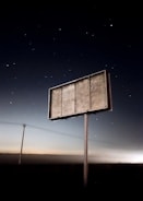a sign in the middle of a field at night