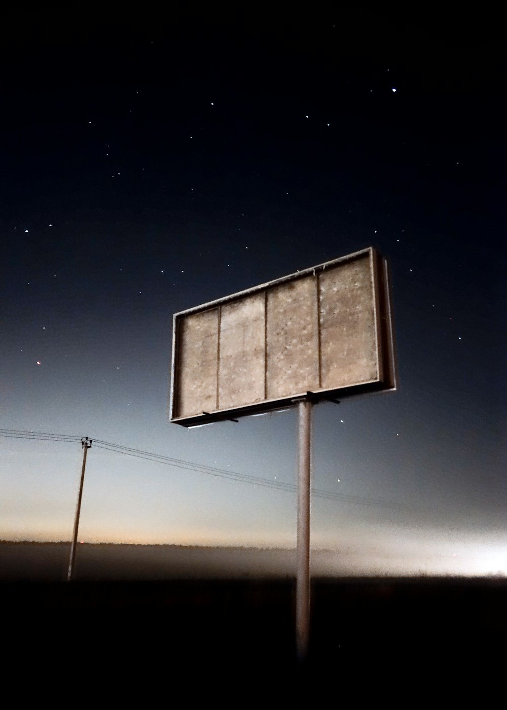 a sign in the middle of a field at night