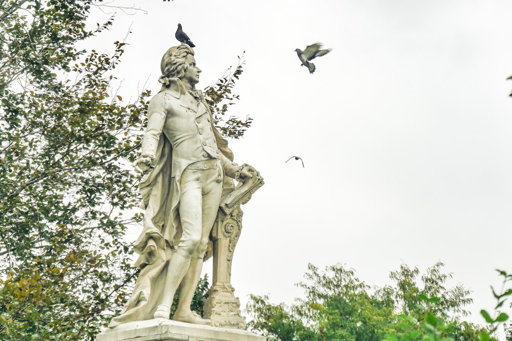 Una estatua de un hombre con un pájaro en el hombro