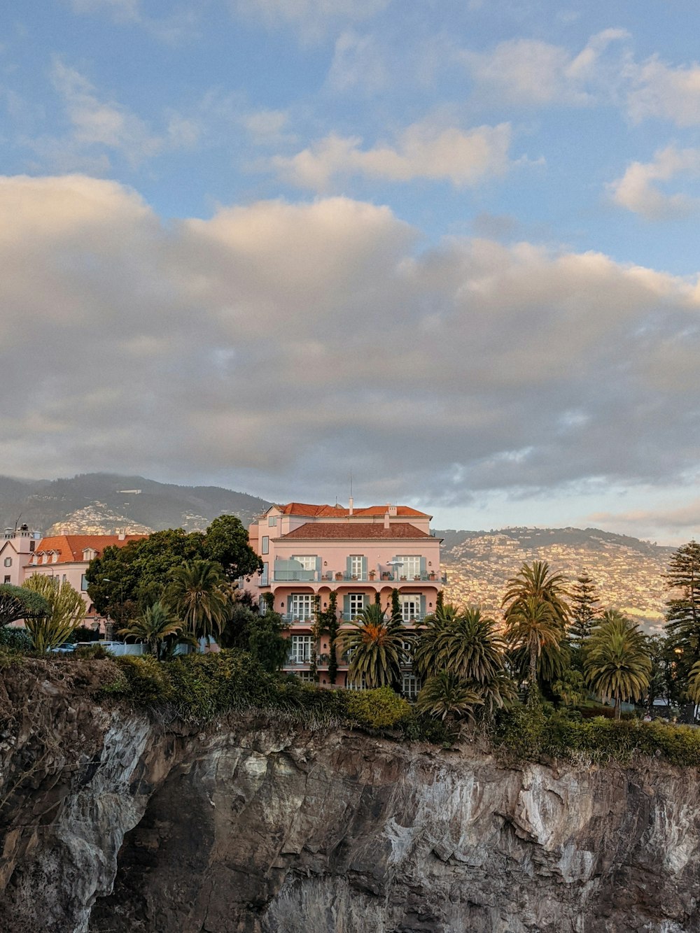 a large building on top of a cliff next to a body of water