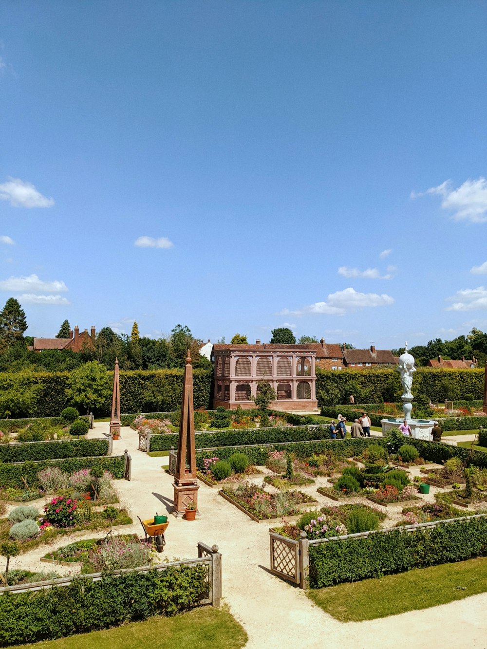 uma vista de um jardim com um grande edifício ao fundo