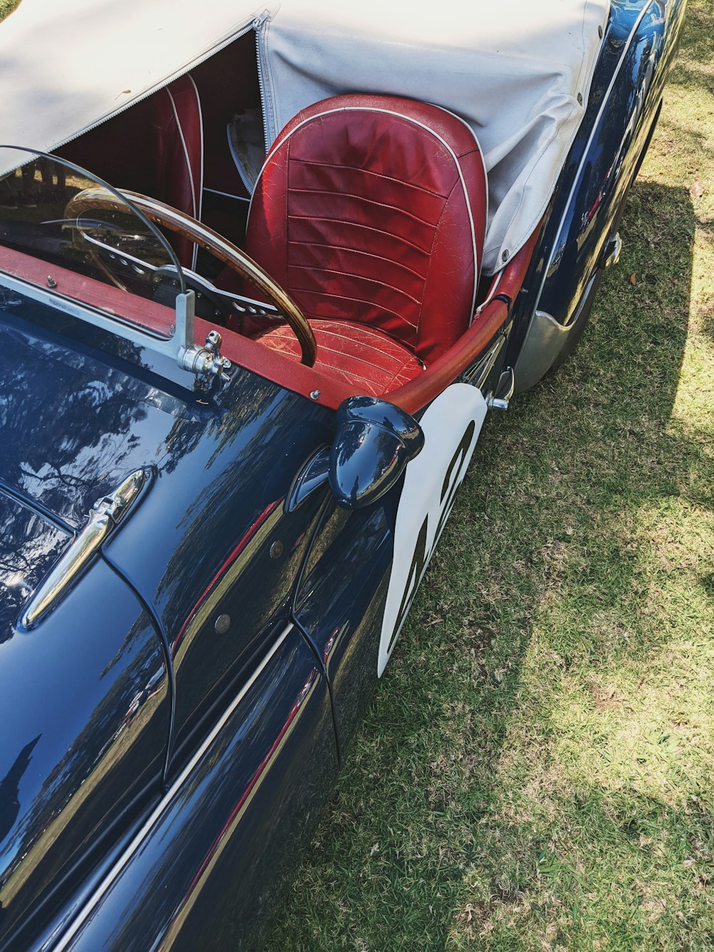 a blue sports car with a red seat cover on it