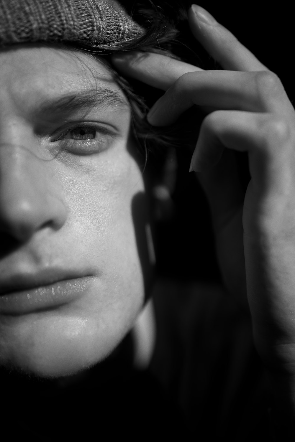 a black and white photo of a man with a beanie