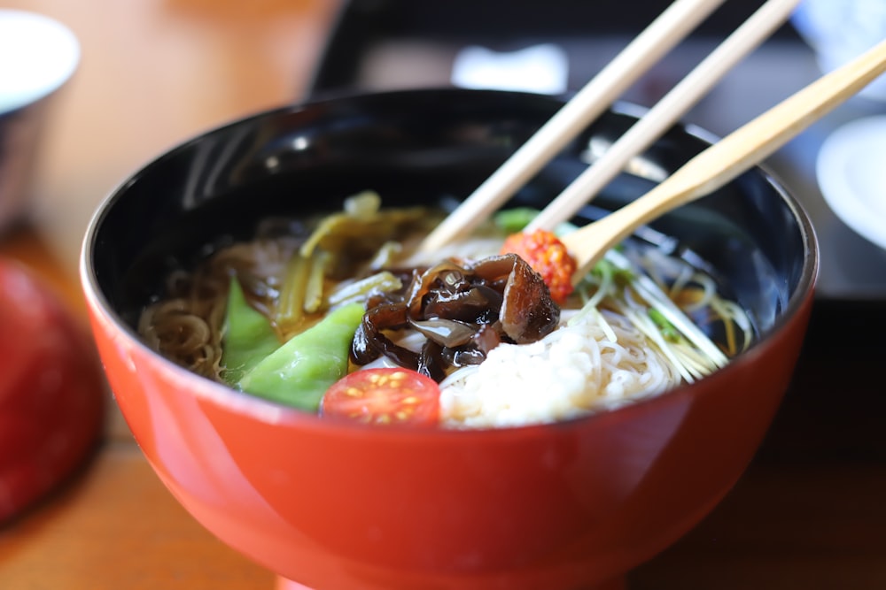 a bowl of food with chopsticks sticking out of it