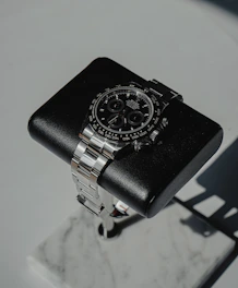 Sophisticated men's silver watch displayed on a polished dark marble slab