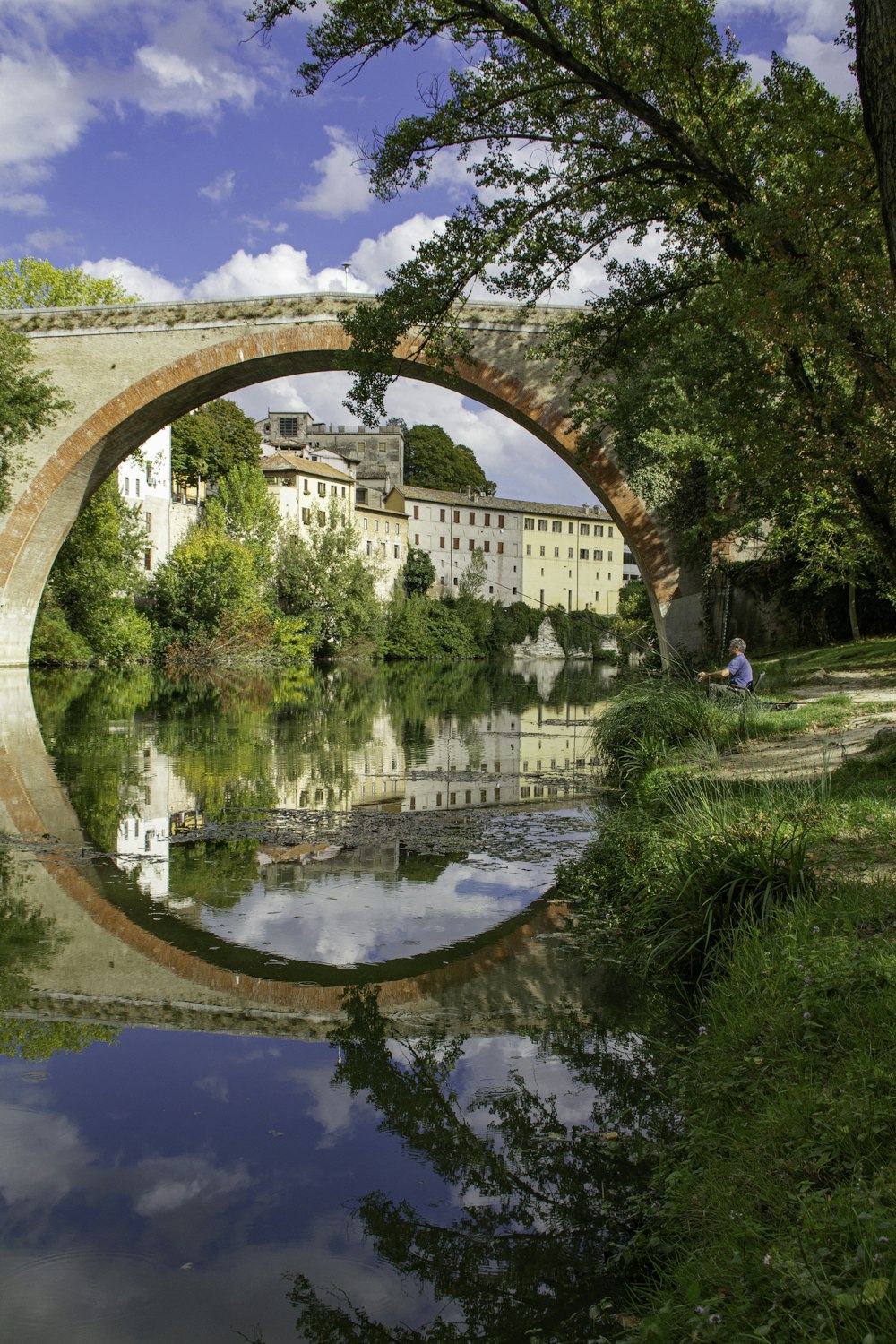 a bridge over a body of water with buildings in the background