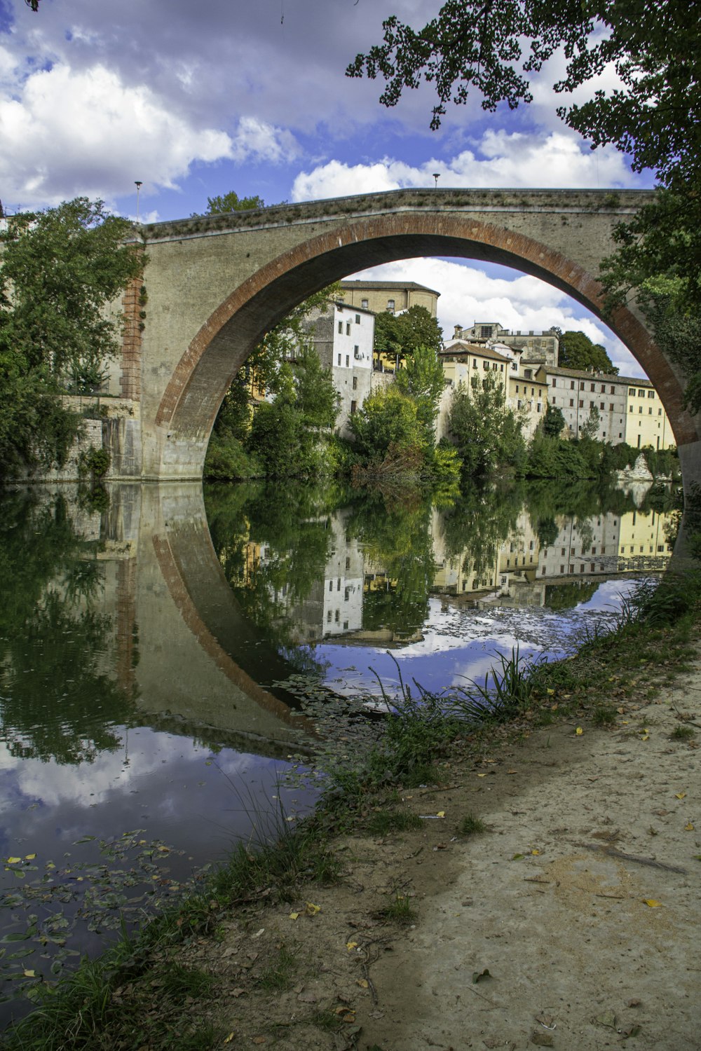 a bridge over a body of water with buildings in the background