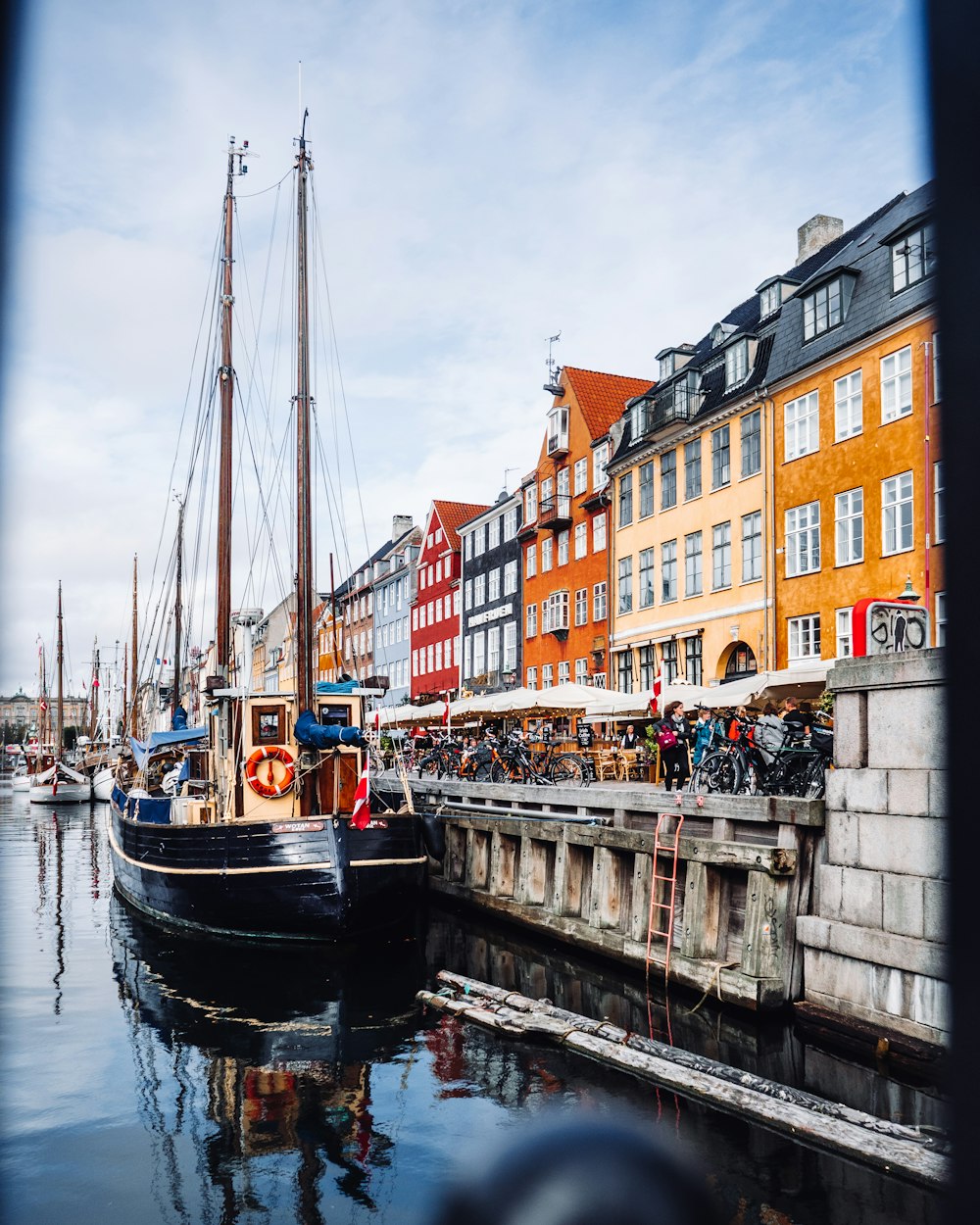 a boat is docked in the water next to a row of buildings