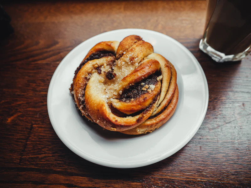A pastry on a plate on a timber table