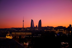 a sunset view of a city with tall buildings