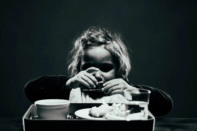 a woman sitting at a table with a tray of food