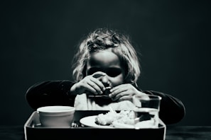 a woman sitting at a table with a tray of food