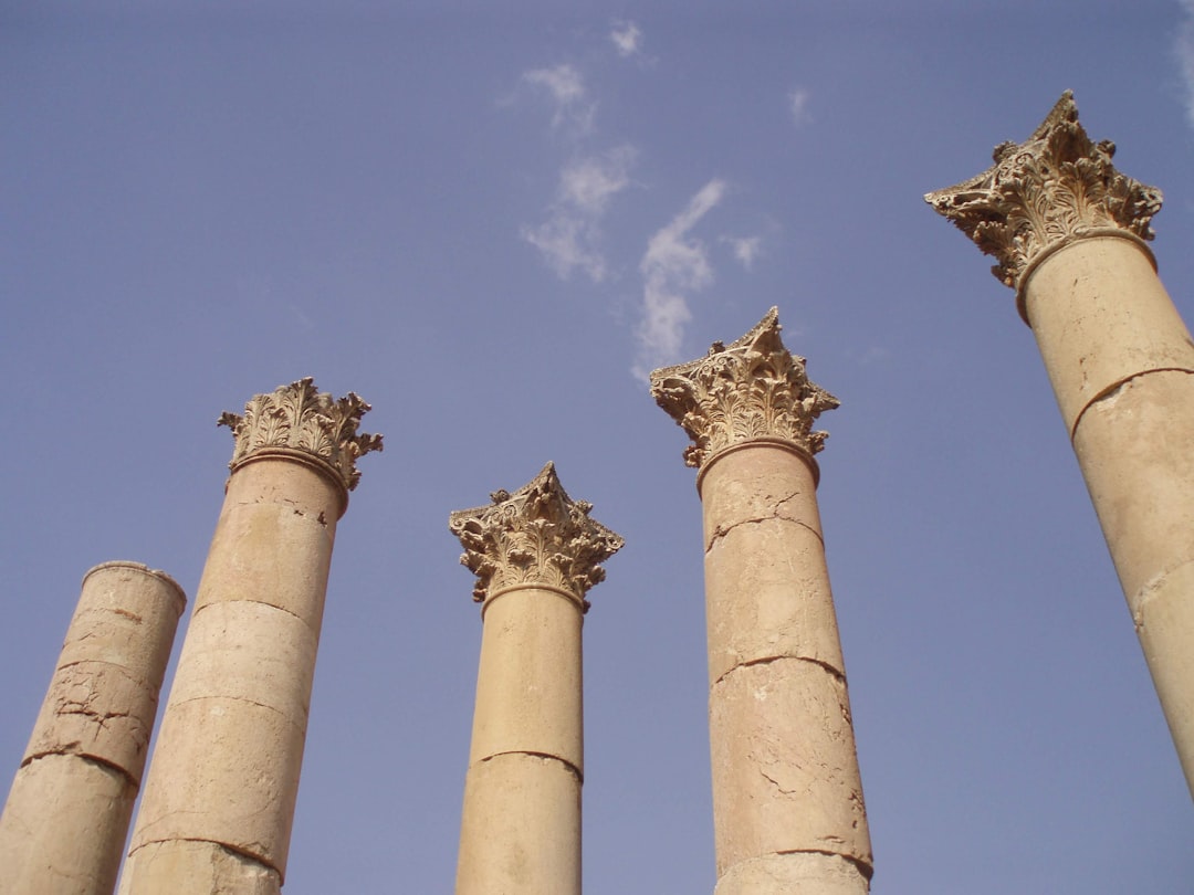 a group of four stone pillars against a blue sky