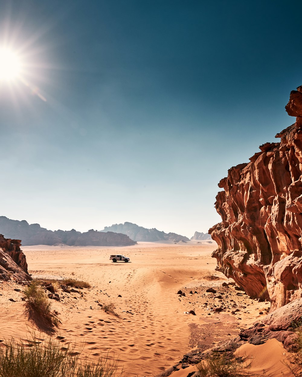 a jeep driving down a dirt road in the desert