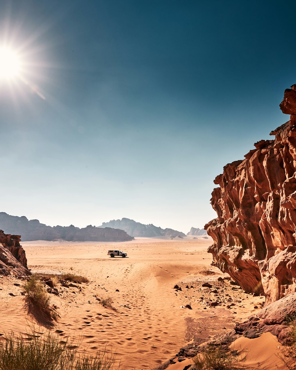 Ein Jeep fährt eine unbefestigte Straße in der Wüste hinunter