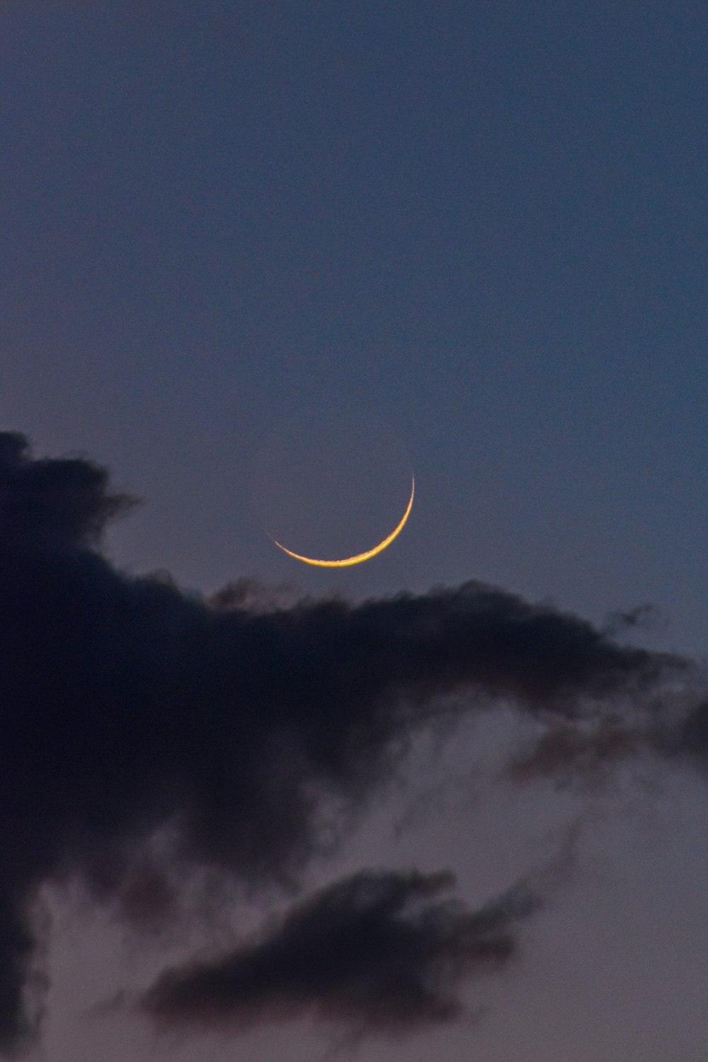 a crescent moon is seen in the night sky