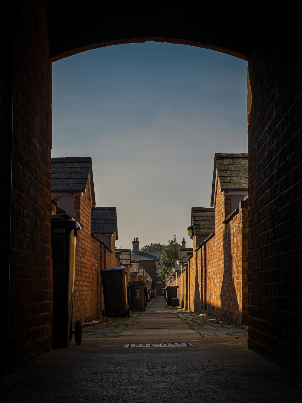 a narrow alley way with brick buildings on either side