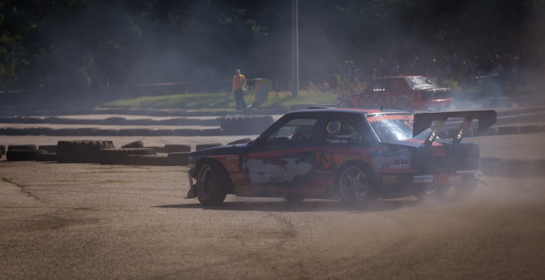 a car with smoke coming out of it driving on a track,
