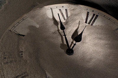 An ultra-realistic close-up of an ancient clock with shadows creeping over its face.