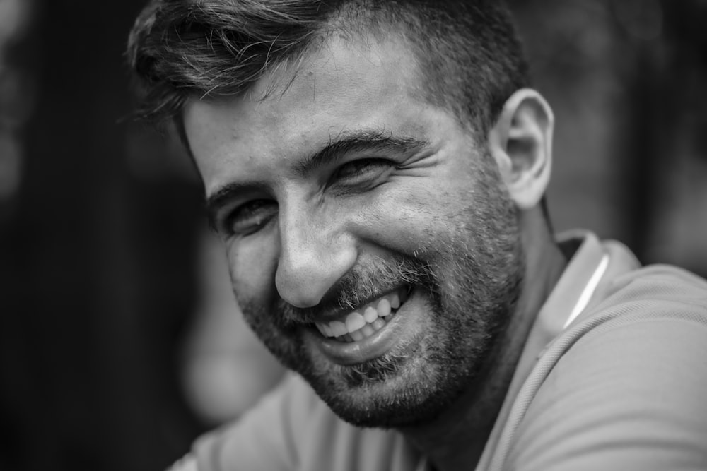 a black and white photo of a smiling man