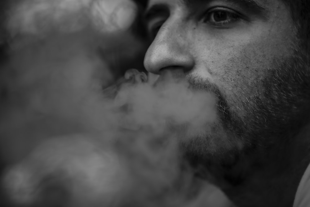 a man smoking a cigarette in a black and white photo