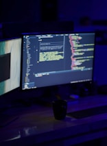A developer coding with AI-powered tools on dual monitors in a cozy workspace.