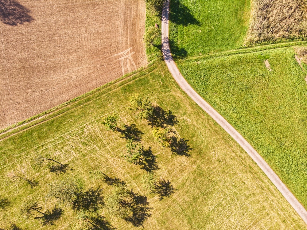 an aerial view of a dirt road in a field
