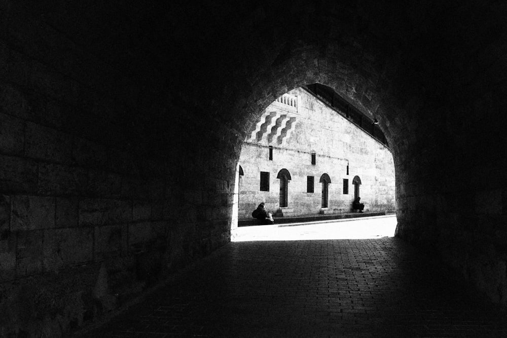 a black and white photo of a dark tunnel