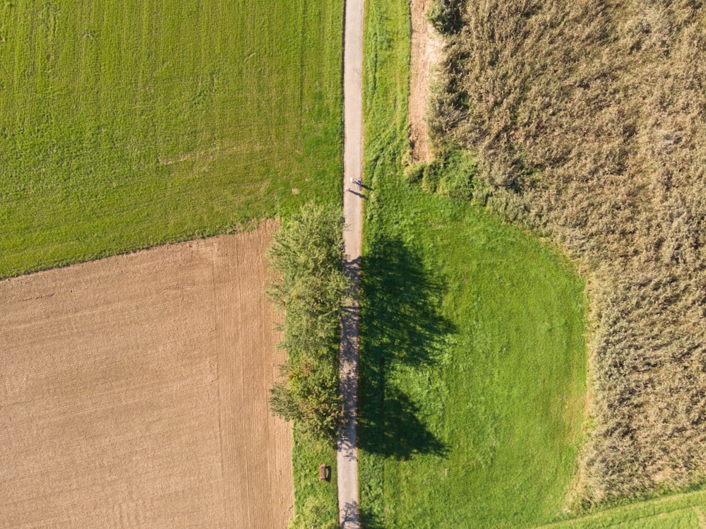 an aerial view of a dirt road in the middle of a field