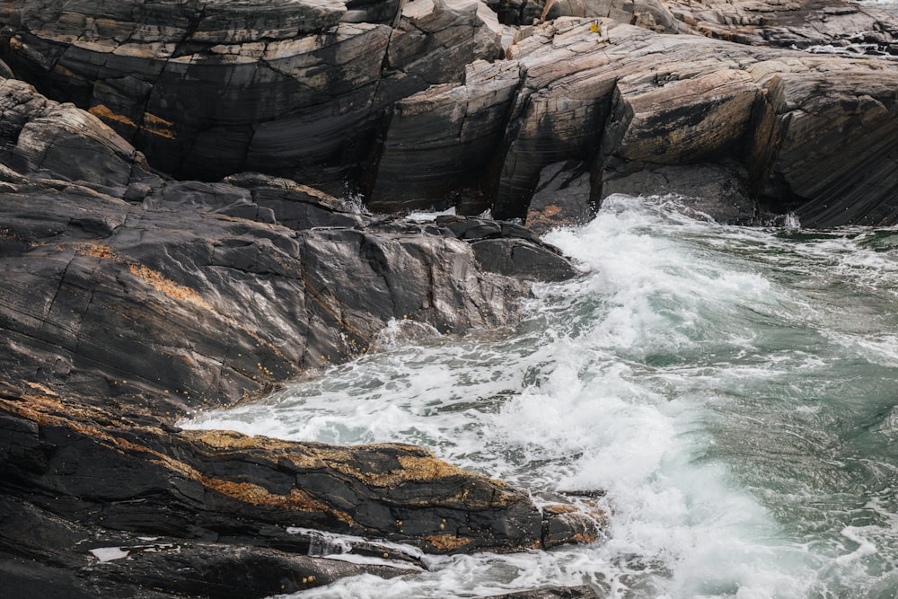 a rocky shore with waves crashing against the rocks