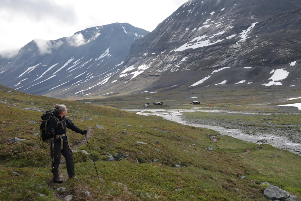 a man hiking up a hill in the mountains