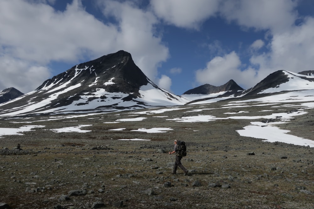 a man walking across a snow covered field