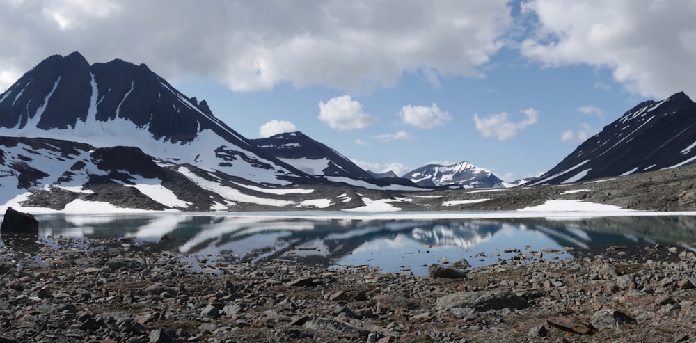 a mountain range with a lake in the foreground