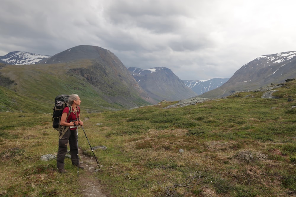 a man with a backpack on a trail in the mountains