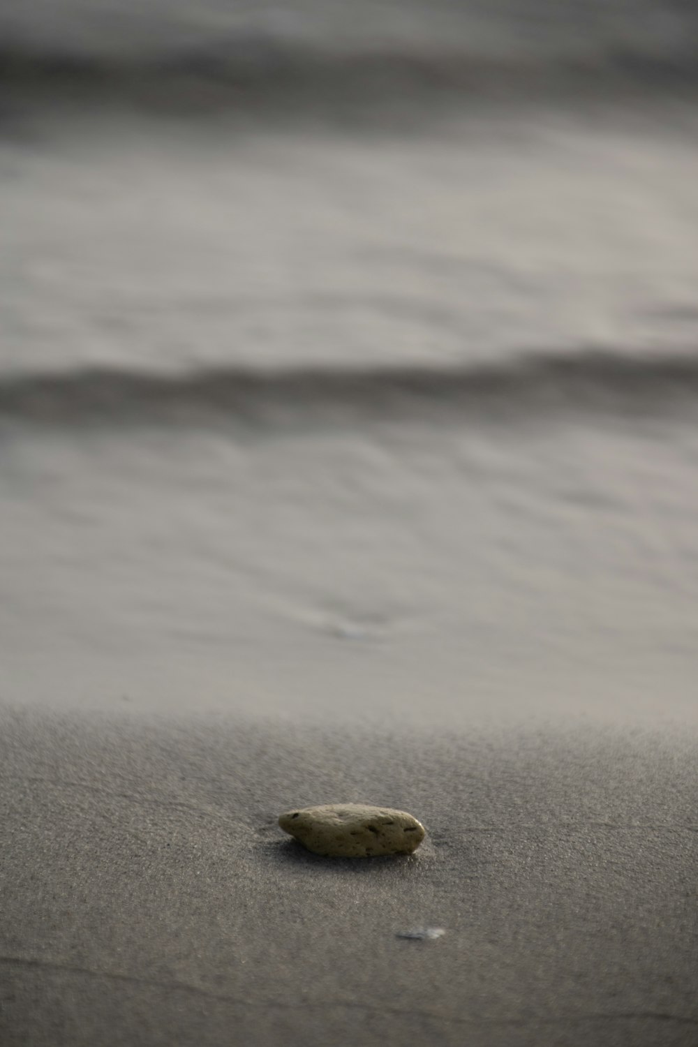 a rock on the sand of a beach