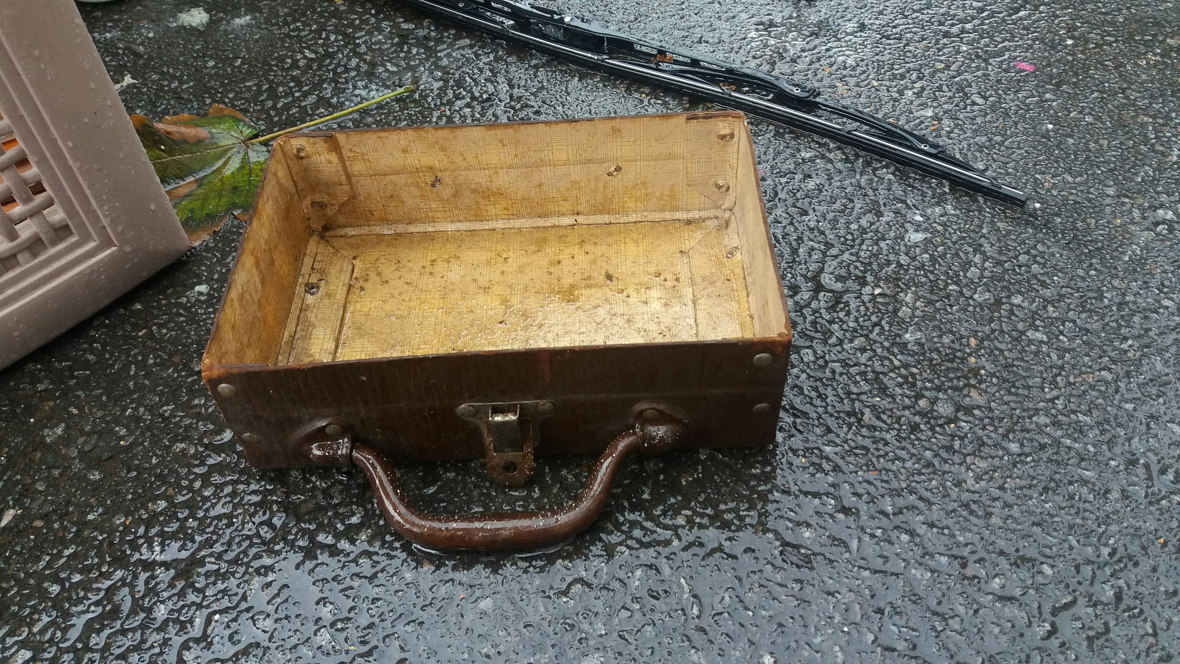 a wooden box sitting on top of a wet ground